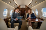 Kieran coaching in sophisticated suit inside private jet cabin